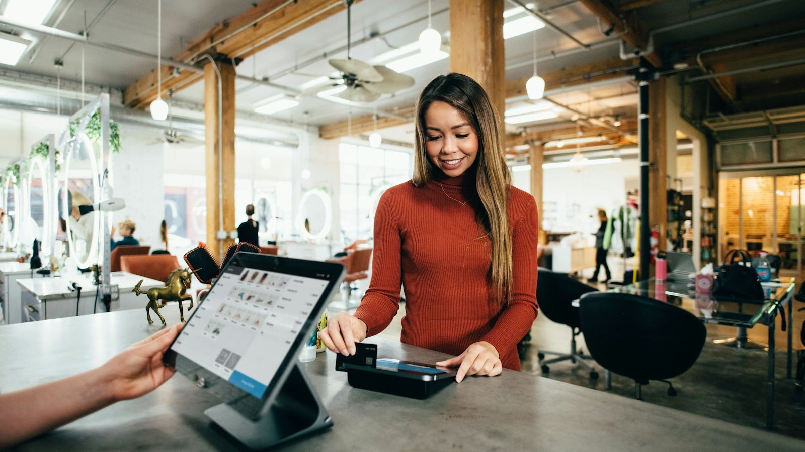 Commerçante accueillant une cliente dans sa boutique de proximité.
